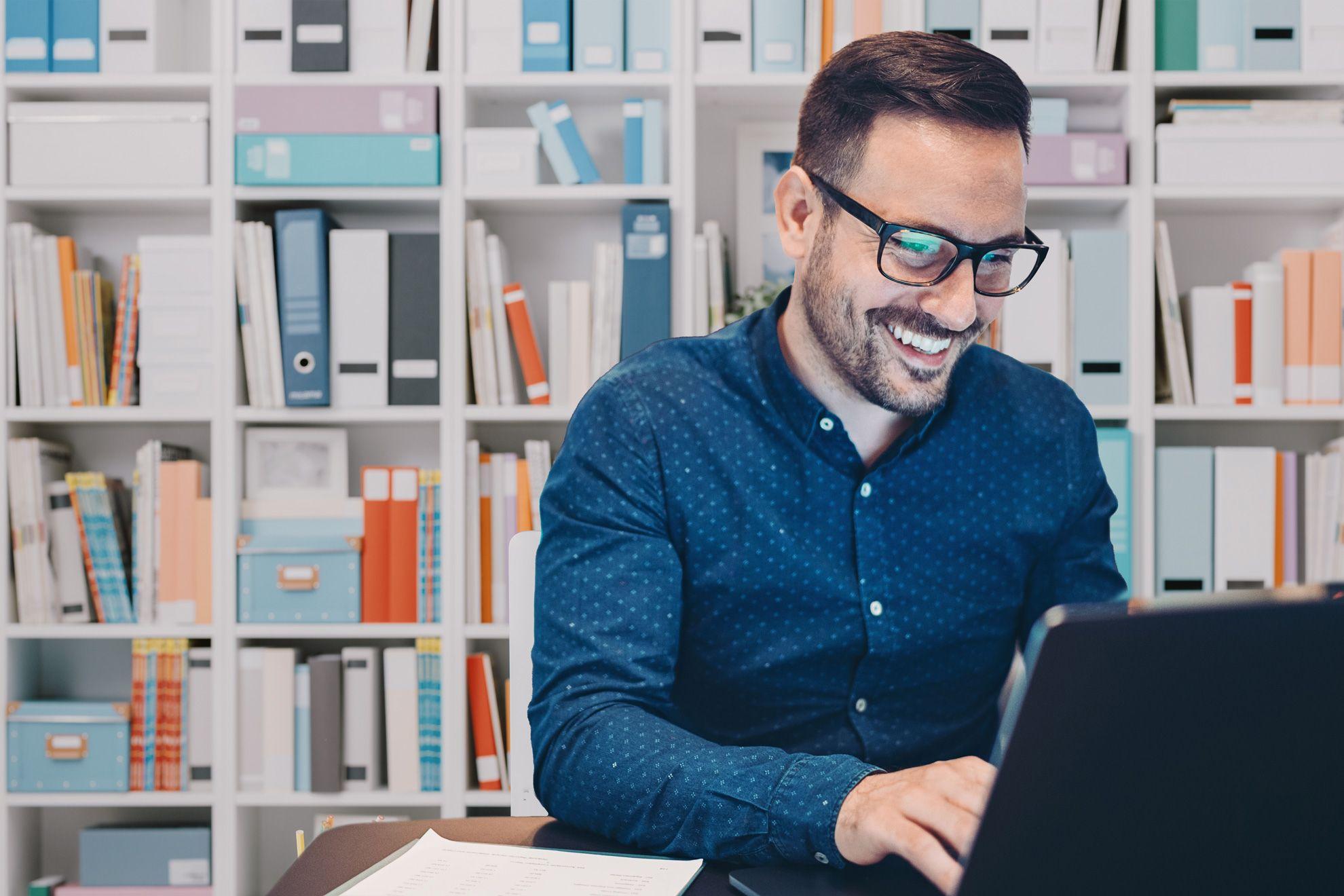 Glücklicher ERP-Nutzer arbeitet am Laptop